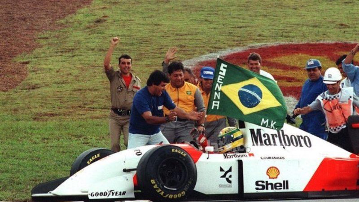 Ayrton Senna sosteniendo una bandera de Brasil tras una victoria